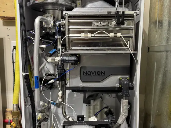 Navien condensing tankless water heater with the cover off during service